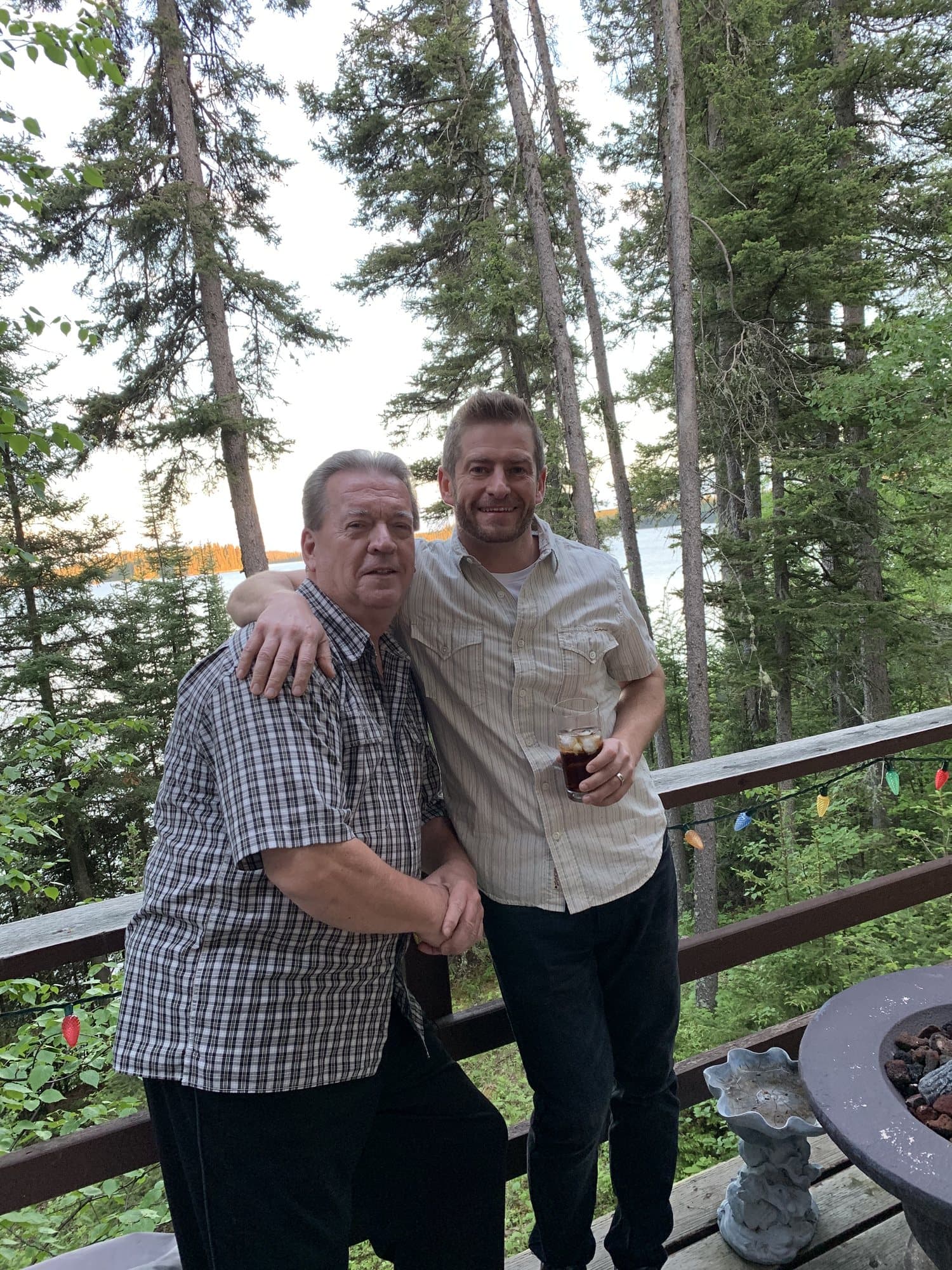 Shea Sanche with his father's advisor, later his business partner, on a deck by a lake