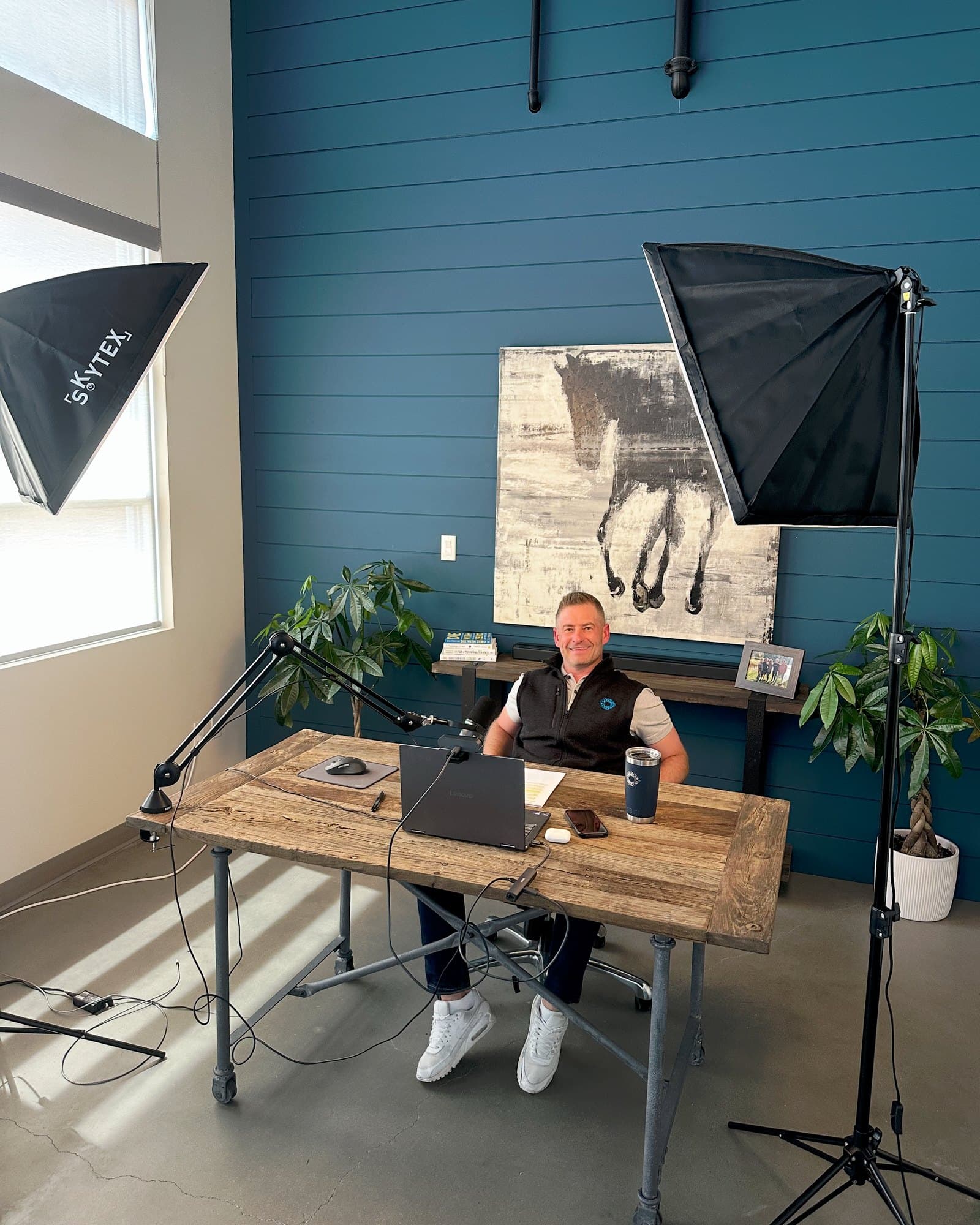 Shea Sanche at his desk in the studio, lights and microphone set up